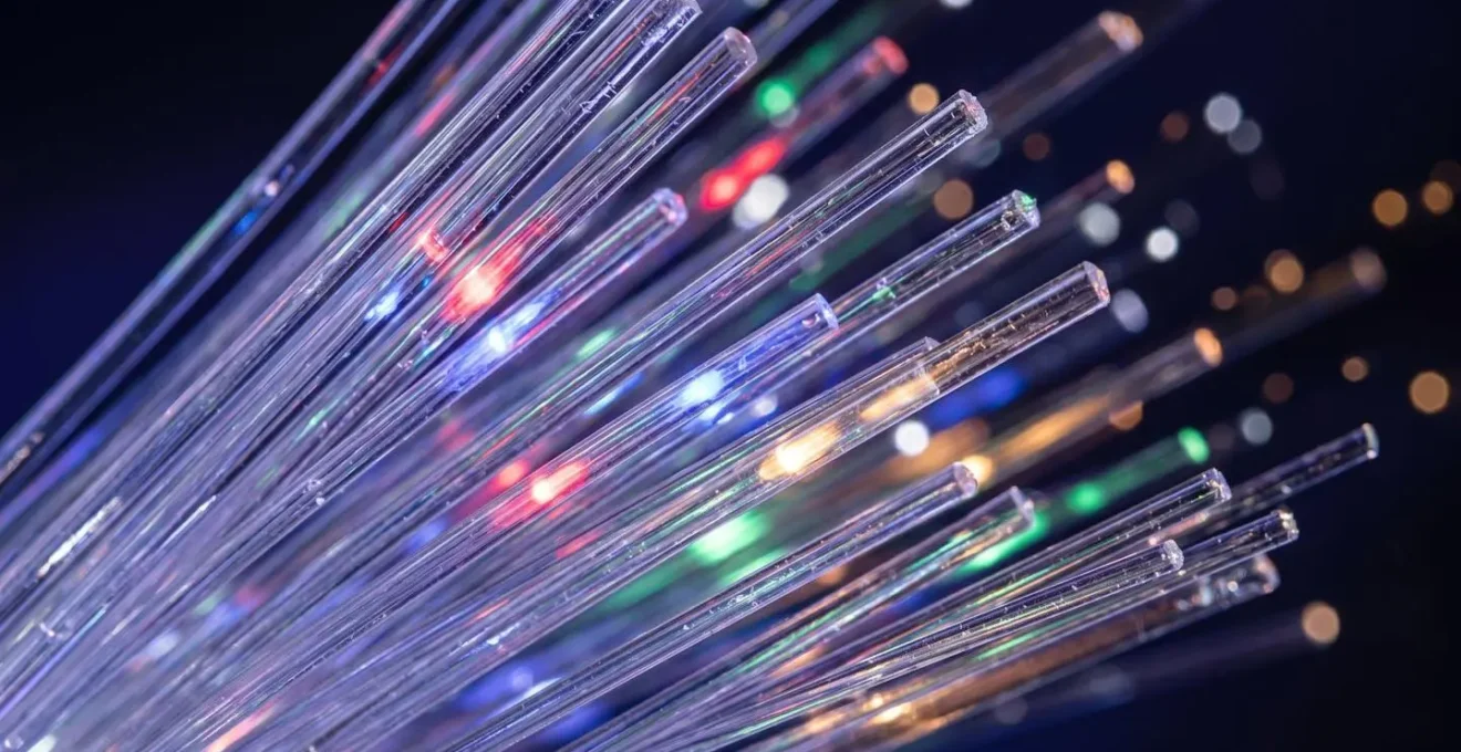 An extreme close-up of fiber optic cables with light pulses suggesting rapid data transmission and speed.